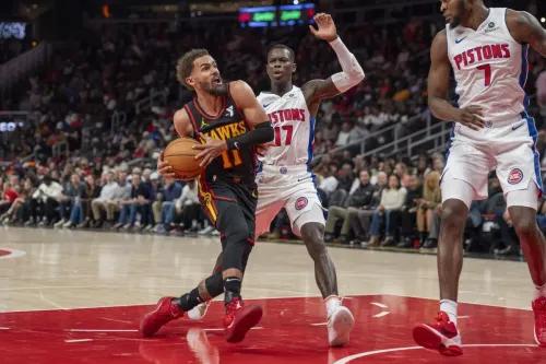 تراي يونغ يتلاعب بالكرة وسط ضغط من لاعبي ديترويت بيستونز، في مباراة حماسية انتهت بفوز البيستونز 148-143.