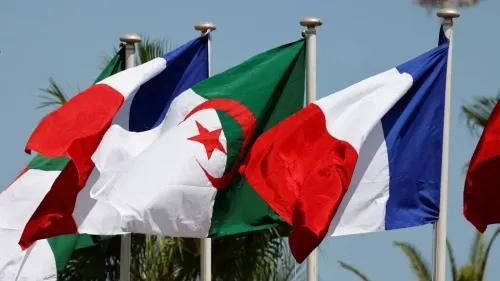 أعلام الجزائر وفرنسا وإيطاليا ترفرف معًا، تعكس التوترات الدبلوماسية بين الجزائر وفرنسا في سياق تاريخي معقد.