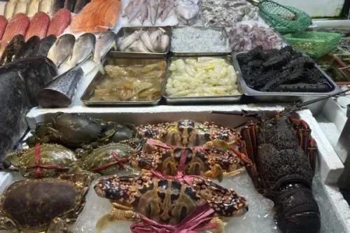 تشكيلة متنوعة من المأكولات البحرية، بما في ذلك الأسماك والجمبري والسلطعونات، في سوق للأسماك، تعكس استئناف واردات اليابان بعد رفع الحظر.