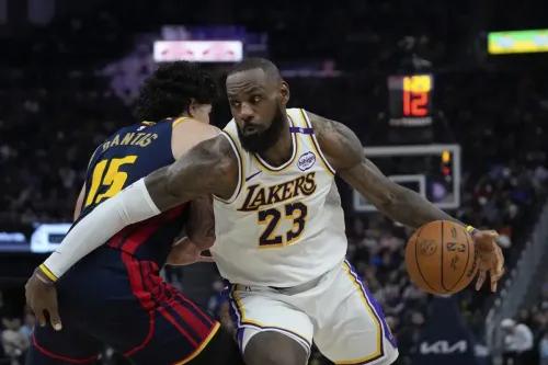 ليبرون جيمس لاعب لوس أنجلوس ليكرز يتجاوز لاعب جولدن ستيت ووريورز بينما يحمل كرة السلة، خلال مباراة مثيرة في الدوري الأمريكي للمحترفين.