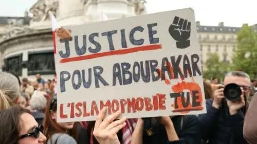 لافتة في احتجاج تطالب بالعدالة لأبو بكر، مع عبارة "الإسلاموفوبيا تقتل"، تعكس مشاعر الغضب والحزن تجاه العنف ضد المسلمين.