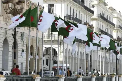 أعلام الجزائر ترفرف في الشارع، تعكس التوترات الدبلوماسية الحالية بين الجزائر وفرنسا عقب طرد دبلوماسيين من كلا البلدين.