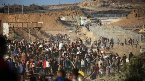 مشهد لمئات الأشخاص يتجمعون في منطقة قريبة من معبر كرم أبو سالم في غزة، وسط توترات أمنية وصراعات على المساعدات الإنسانية.