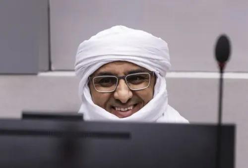 الحسن أغ عبد العزيز أغ محمد أغ محمود، زعيم متطرف، مبتسم أثناء جلسة محاكمته في المحكمة الجنائية الدولية بتهمة ارتكاب جرائم حرب.
