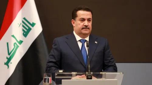 رئيس الوزراء العراقي محمد شياع السوداني يتحدث في مؤتمر صحفي، خلفه العلم العراقي، معبرًا عن إدانته للهجمات على العمال السوريين.