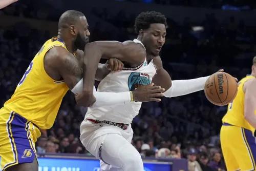 ليبرون جيمس ينافس لاعب ممفيس غريزليز في مباراة كرة السلة، مع التركيز على الكرة في يد اللاعب الآخر.