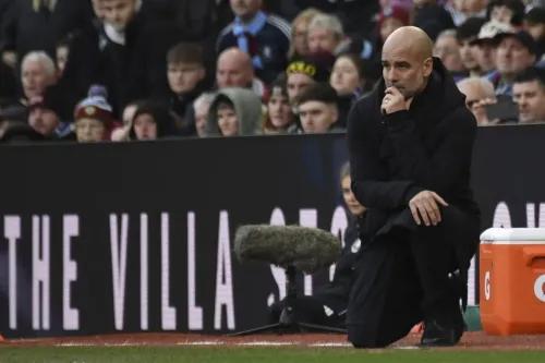 بيب جوارديولا، مدرب مانشستر سيتي، وهو يجلس على ركبتيه على خط الملعب، مع تعبيرات تفكير أثناء مباراة ضد أستون فيلا.