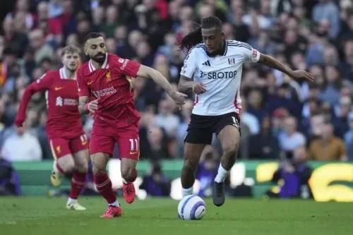 محمد صلاح يتنافس مع لاعب من فولهام خلال مباراة في الدوري الإنجليزي الممتاز، حيث يسعى ليفربول لتحقيق المزيد من الألقاب.