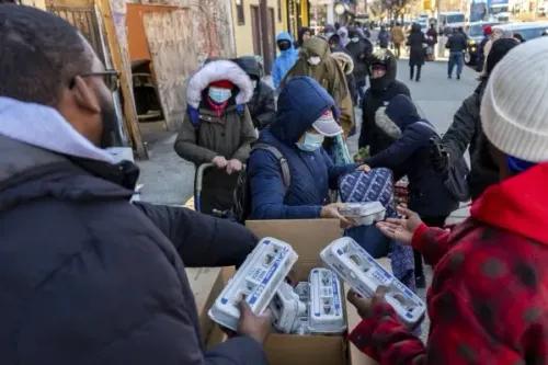 تجمع عدد من الأشخاص في نيويورك للحصول على كراتين بيض مجانية، وسط طقس بارد، في حدث نظمته مزرعة FarmerJawn لدعم المجتمعات.