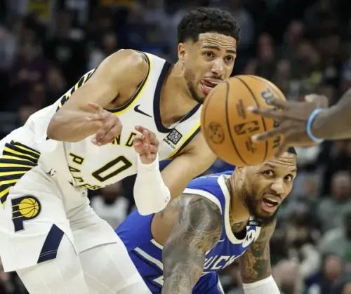 تيريس هاليبورتون من إنديانا بيسرز يتنافس مع لاعب ميلووكي باكس على الكرة، مما يعكس التوتر في مباراة حماسية بين الفريقين.