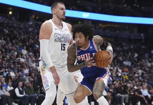 مواجهة بين نجم دينفر ناغتس نيكولا جوكيتش ولاعب فيلادلفيا تيريس ماكسي، حيث يحمل ماكسي الكرة في محاولة لاختراق الدفاع.
