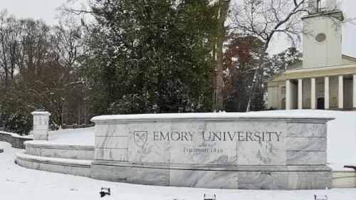 جامعة إيموري تحت الثلوج، مع لافتة تحمل اسم الجامعة وتاريخ تأسيسها، تعكس أجواء الاحتجاجات الطلابية حول قضايا غزة.