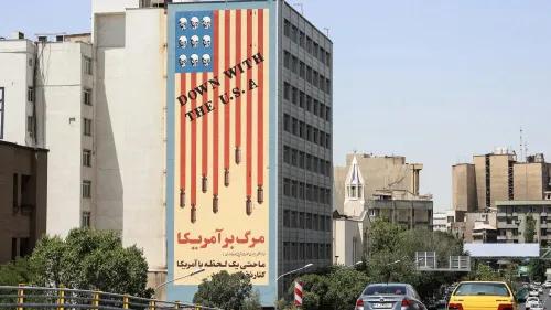 لافتة كبيرة في طهران تحمل عبارة "الموت لأمريكا" مع رسومات توضح أسلحة وصور جماجم، تعكس مشاعر معارضة تجاه الولايات المتحدة.