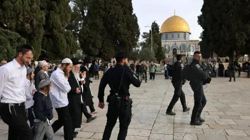 مستوطنون إسرائيليون يتجولون في باحات المسجد الأقصى تحت حماية الشرطة، مع قبة الصخرة في الخلفية، وسط توتر متزايد.