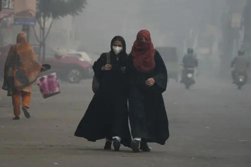 امرأتان ترتديان ملابس داكنة وأقنعة وجه، تسيران في شوارع لاهور المليئة بالضباب الدخاني، وسط تحذيرات من تلوث الهواء.