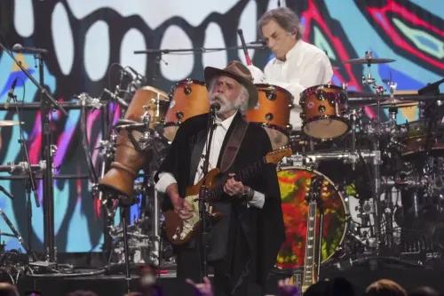 عازف الجيتار بوب وير يؤدي على المسرح خلال حفل تكريم فرقة Grateful Dead، مع خلفية ملونة وأجواء احتفالية.