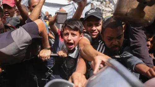 صورة لمجموعة من الأشخاص، بينهم طفل، يتزاحمون للحصول على المساعدات الإنسانية في غزة، مع تعبيرات تدل على الحاجة الملحة.