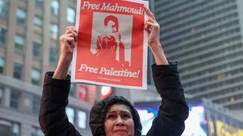 امرأة تحمل لافتة تطالب بإطلاق سراح محمود وتدعو للحرية لفلسطين، في تجمع احتجاجي يعكس التضامن مع القضايا الفلسطينية.